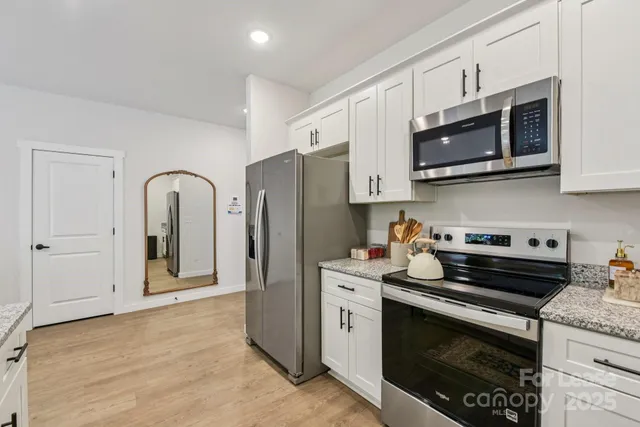 a kitchen with stainless steel appliances granite countertop a stove a microwave and a refrigerator