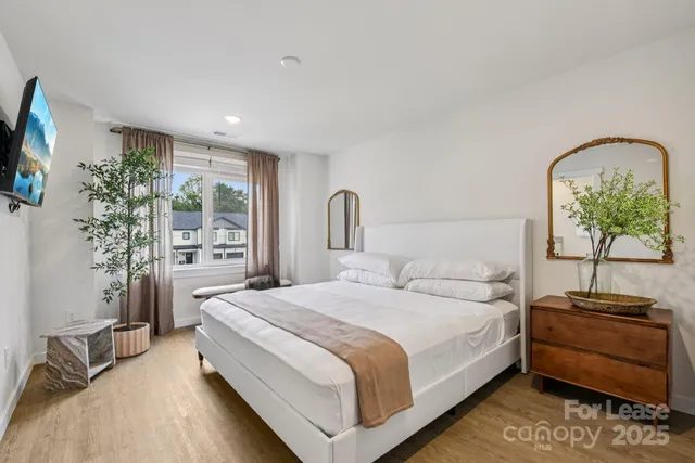 a bedroom with a bed and a potted plant