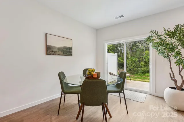 a dining room with furniture and a potted plant