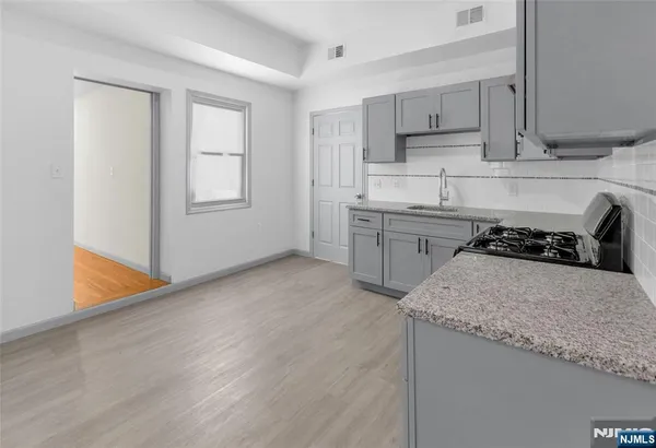 a kitchen with granite countertop a sink stove and cabinets