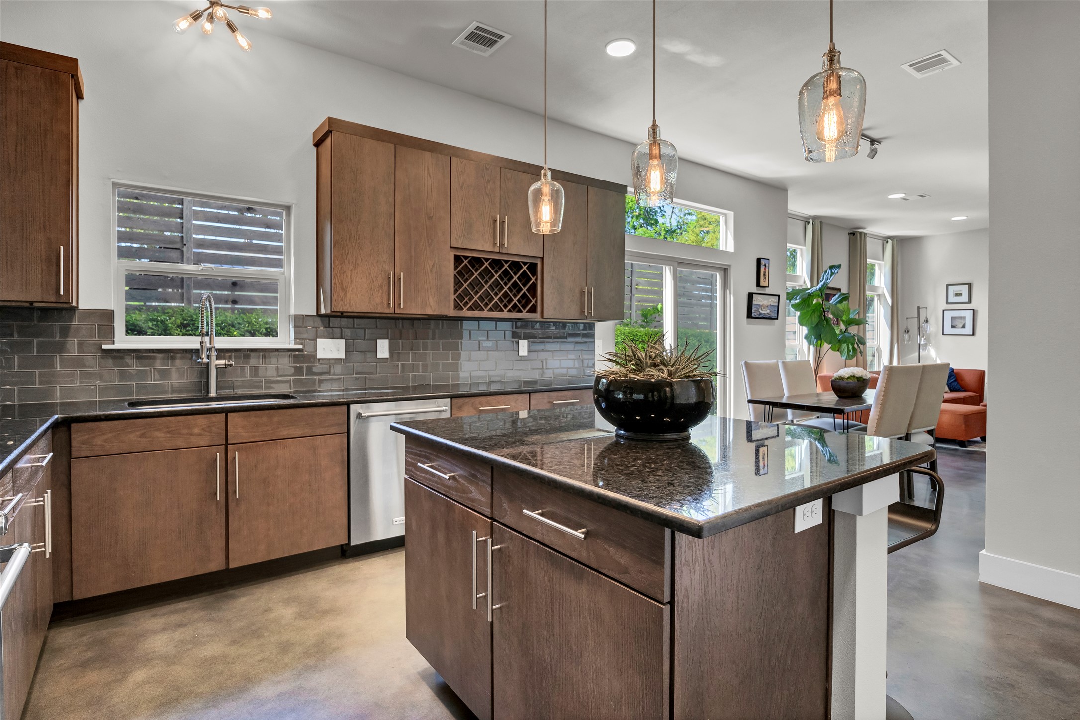Kitchen with pendant lighting, finished concrete floors, a kitchen island, and dishwasher