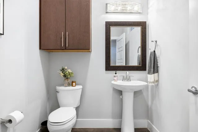 a bathroom with a toilet a sink and mirror