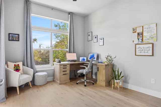 a view of a workspace with furniture and a window