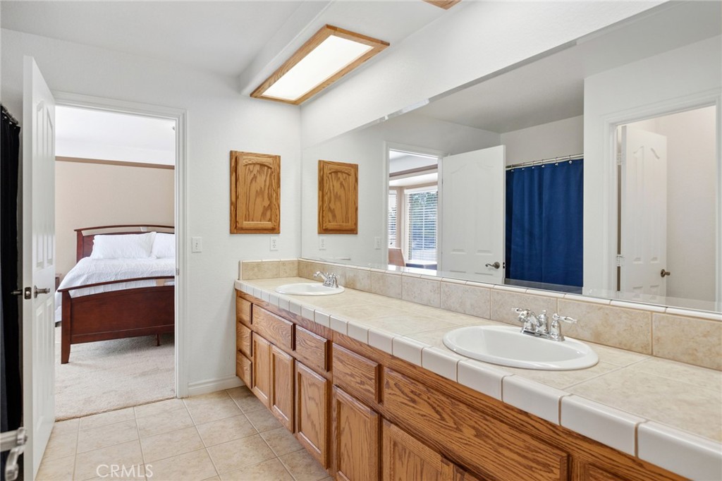 11025 El Esteban Road Phelan, CA 92371 - Photo 28 of 54 a bathroom with a granite countertop double vanity sink and a bathtub