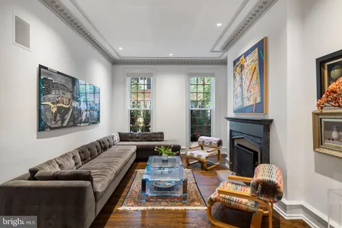 a living room with furniture a fireplace and paintings on wall