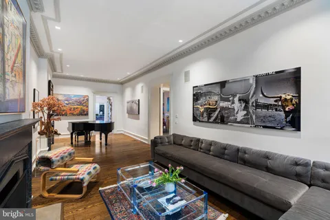 a dining room with furniture a chandelier and wooden floor