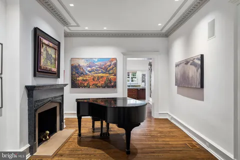 a dining room with wooden floor a chandelier a wooden table and chairs