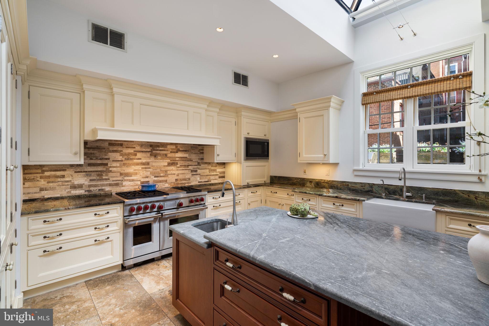1819 Delancey Place Philadelphia, PA 19103 - Photo 24 of 76 a kitchen with stainless steel appliances granite countertop a sink stove and cabinets