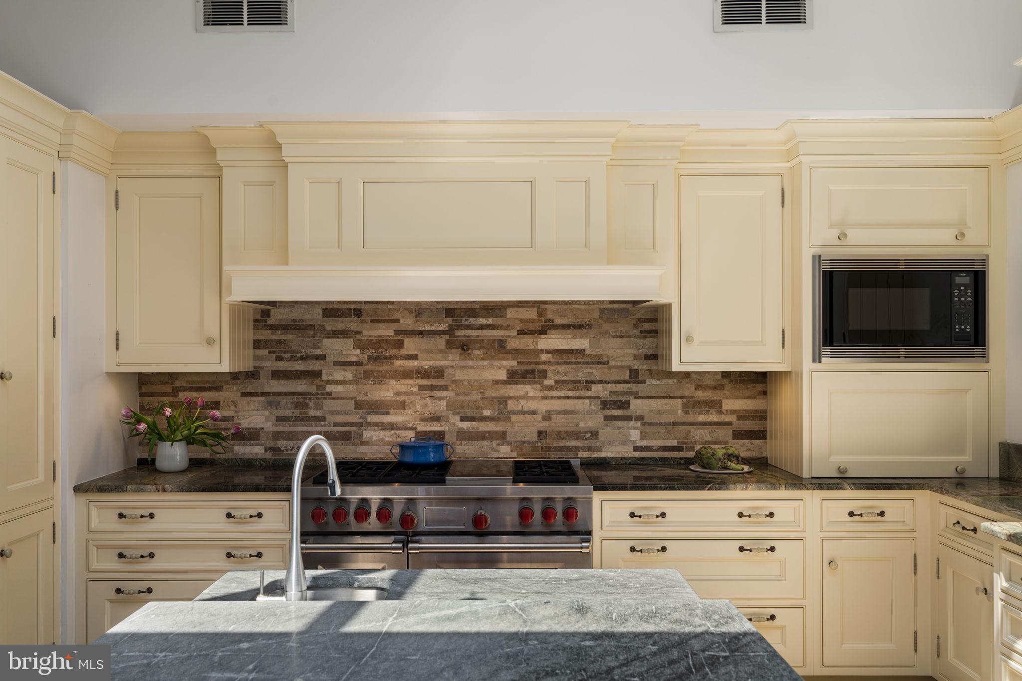 1819 Delancey Place Philadelphia, PA 19103 - Photo 28 of 76 a kitchen with stainless steel appliances kitchen island granite countertop a stove a sink and a microwave