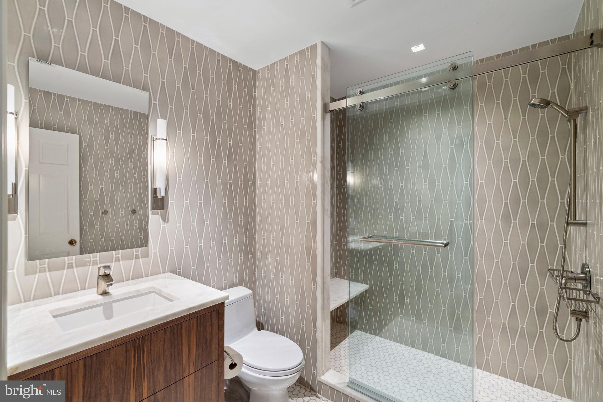 1819 Delancey Place Philadelphia, PA 19103 - Photo 58 of 76 a bathroom with a sink a toilet a mirror a vanity and shower