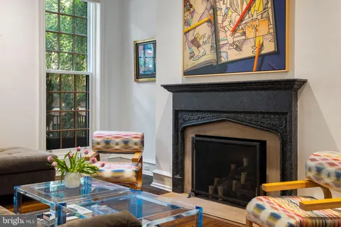 a living room with furniture a fireplace and paintings on wall