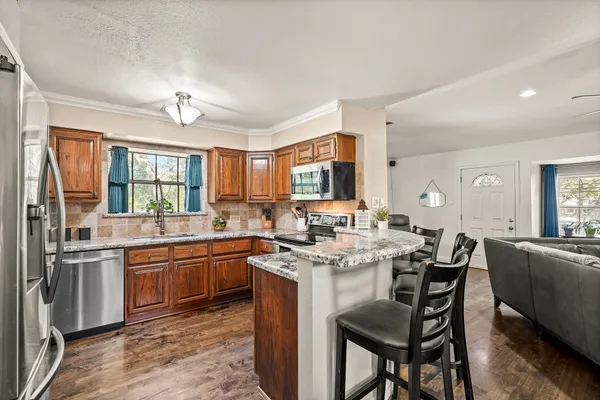 a kitchen with stainless steel appliances granite countertop a stove and cabinets
