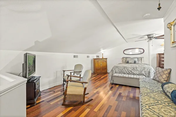 a bedroom with a bed and wooden floor