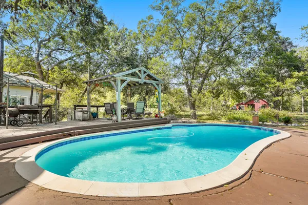 a view of swimming pool with outdoor seating and plants