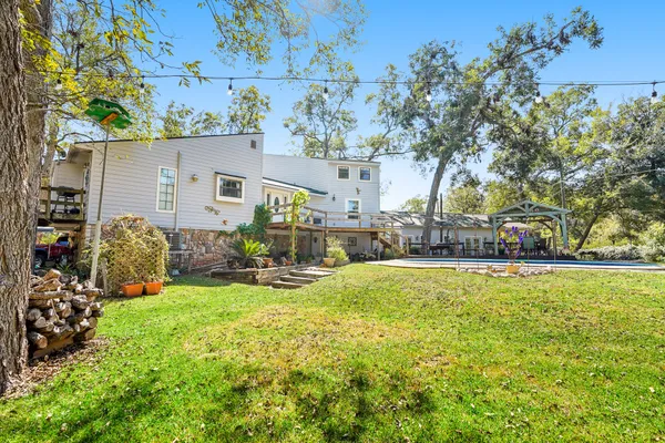 a view of swimming pool with outdoor seating and trees in the background