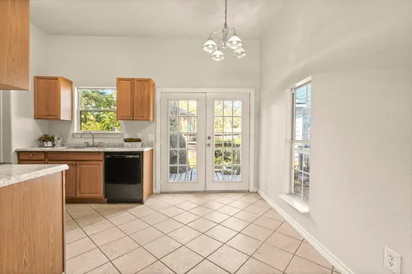 a large kitchen with kitchen island granite countertop a refrigerator a stove a sink dishwasher with a dining table and chairs