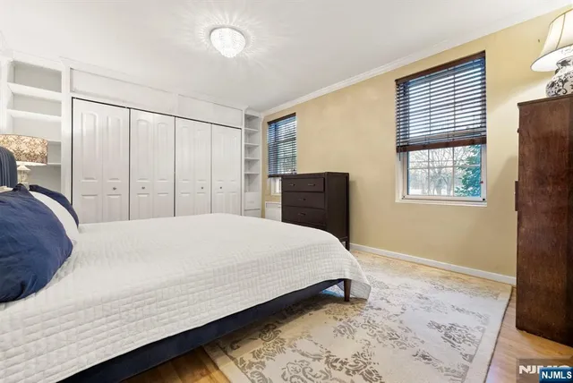 a bedroom with a bed and a dresser next to a window