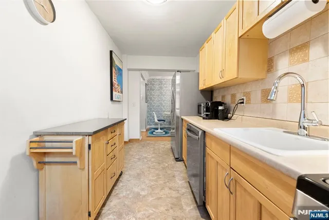 a kitchen with stainless steel appliances granite countertop a sink and a stove