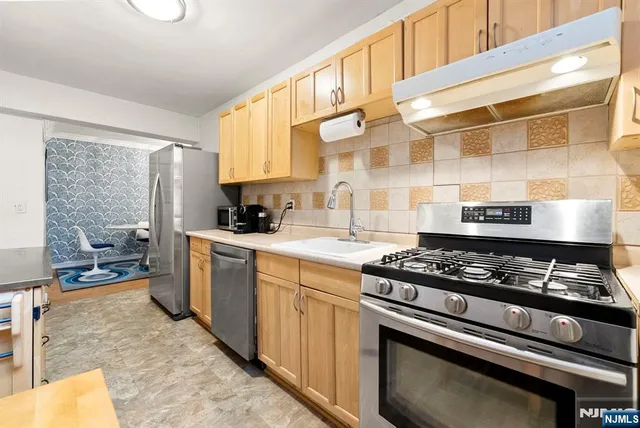 a kitchen with a stove a sink and a cabinets