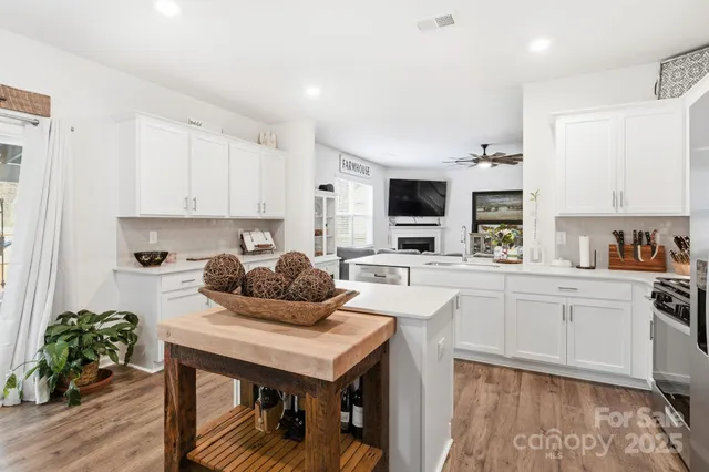a kitchen with granite countertop a table chairs stove and cabinets