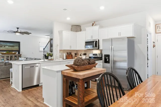 a kitchen with kitchen island a refrigerator stove microwave and cabinets