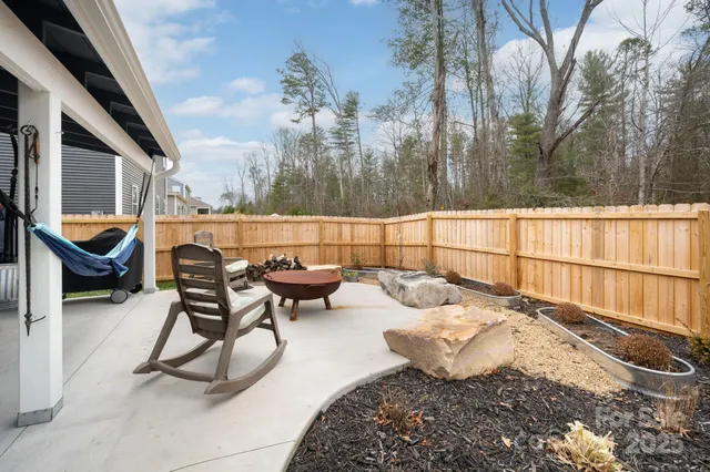 a wooden table sitting in a roof deck with large pool and wooden fence