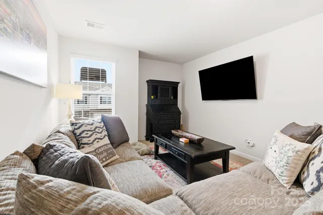 a bedroom with a bed and a flat tv screen on the dresser