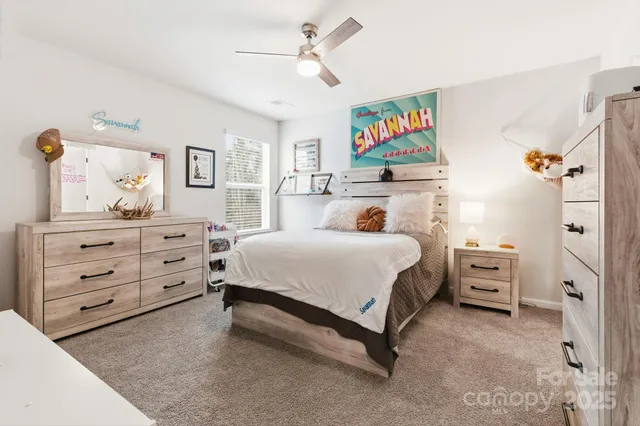 a spacious bedroom with a bed a table and a flat screen tv