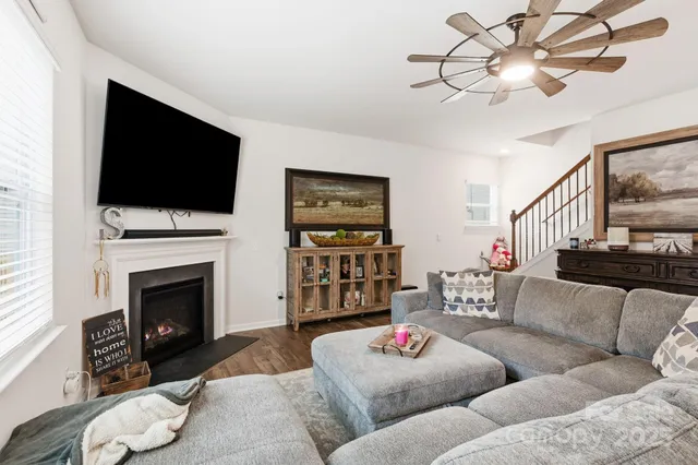 a living room with furniture a flat screen tv and a fireplace