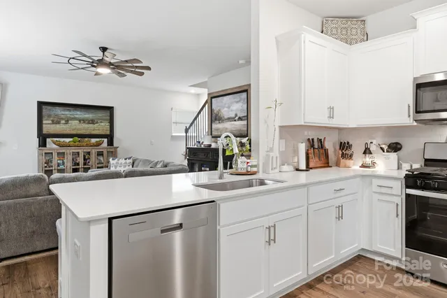 a kitchen with a sink dishwasher and white cabinets