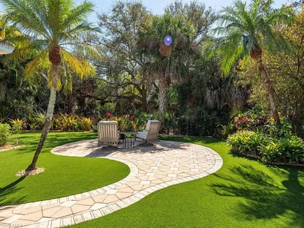 a view of a house with backyard and sitting area