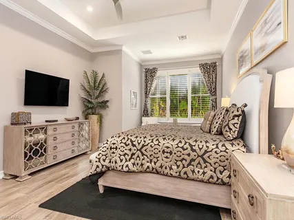 a bedroom with a bed and flat tv screen on the dresser
