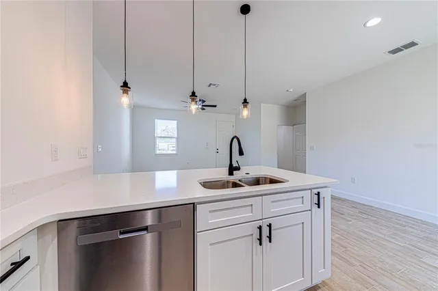 an empty room with wooden floor and ceiling fan