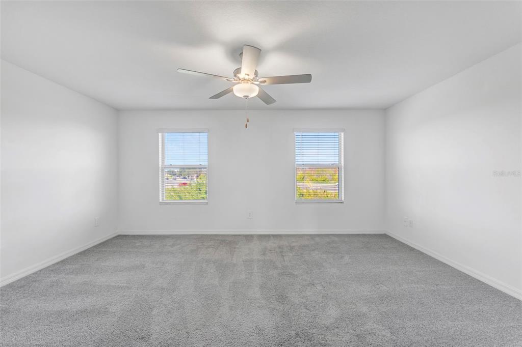 8309 Corner Pine Way New Port Richey, FL 34655 - Photo 15 of 33 an empty room with windows and fan chandelier