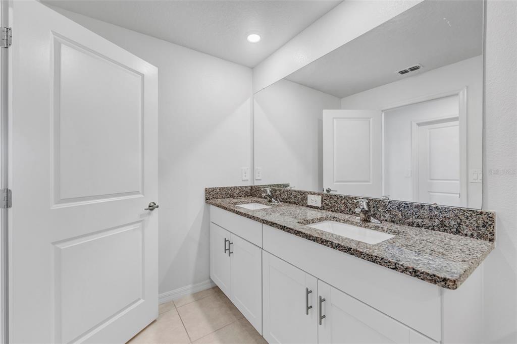 8309 Corner Pine Way New Port Richey, FL 34655 - Photo 19 of 33 a bathroom with a granite countertop sink and a mirror