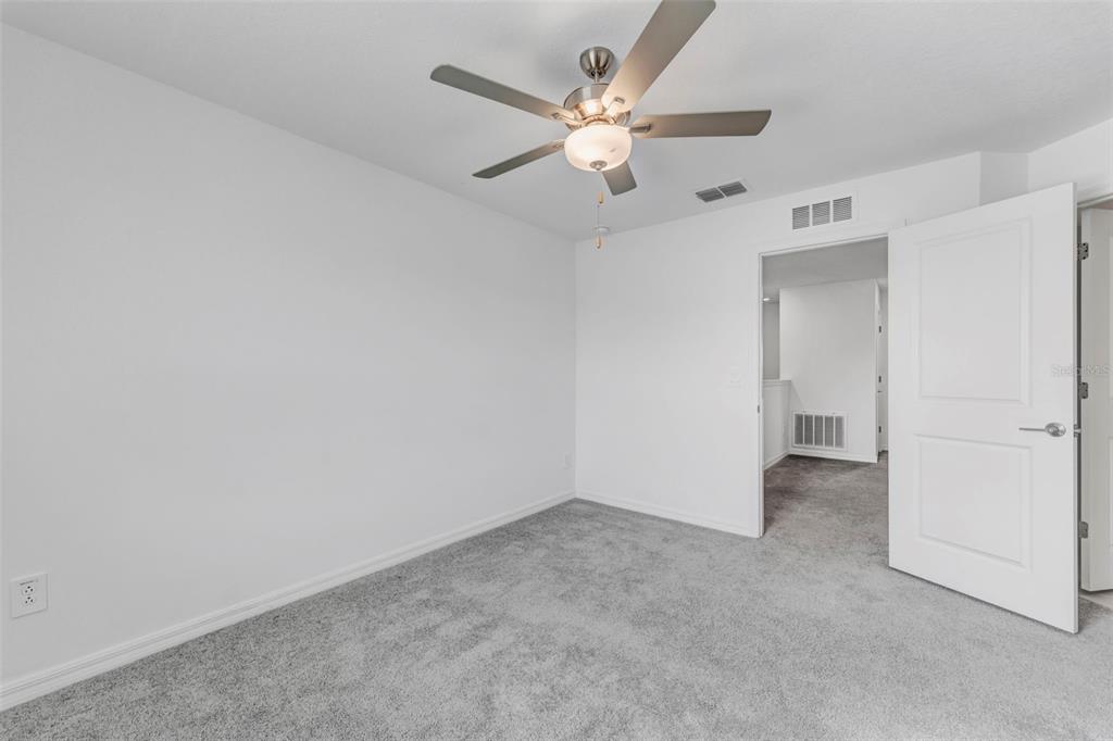 8309 Corner Pine Way New Port Richey, FL 34655 - Photo 24 of 33 an empty room with a ceiling fan and a ceiling fan