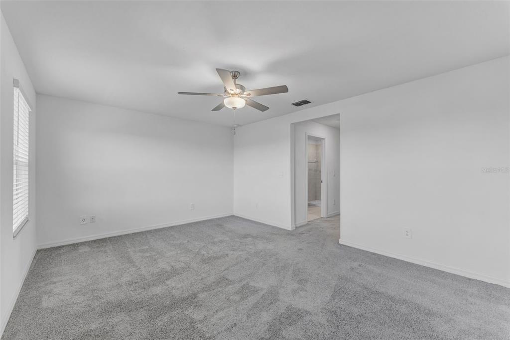 8309 Corner Pine Way New Port Richey, FL 34655 - Photo 26 of 33 an empty room with chandelier fan and windows