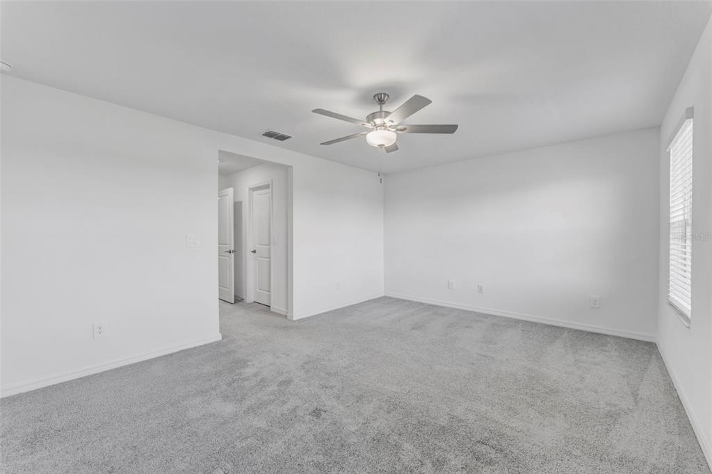 8309 Corner Pine Way New Port Richey, FL 34655 - Photo 27 of 33 an empty room with a window and a ceiling fan