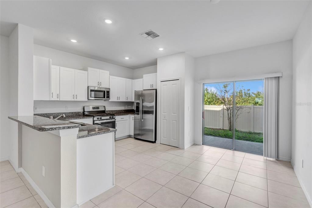 8309 Corner Pine Way New Port Richey, FL 34655 - Photo 4 of 33 a kitchen with stainless steel appliances a refrigerator sink and stove