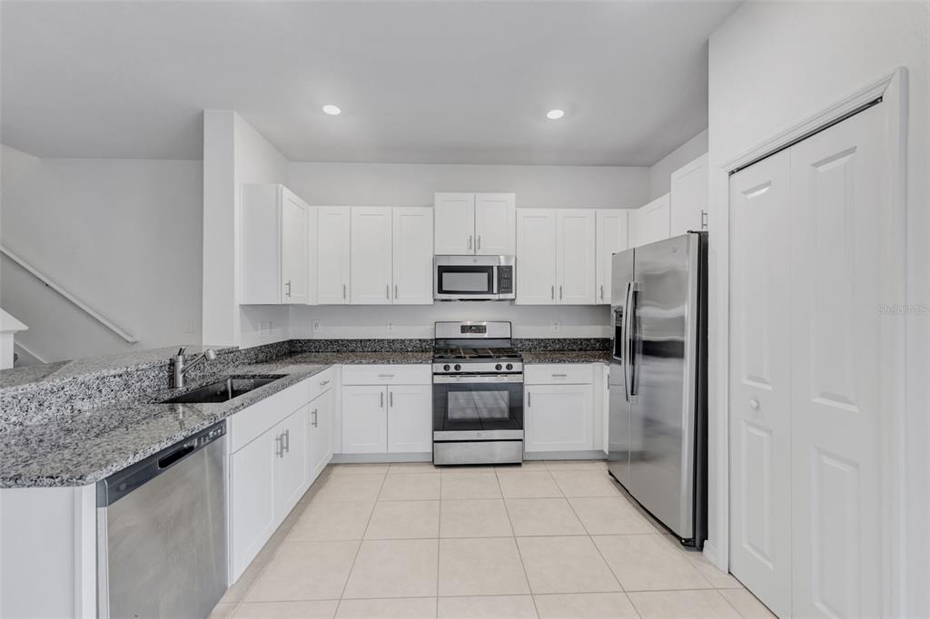8309 Corner Pine Way New Port Richey, FL 34655 - Photo 6 of 33 a kitchen with stainless steel appliances granite countertop a refrigerator and a sink