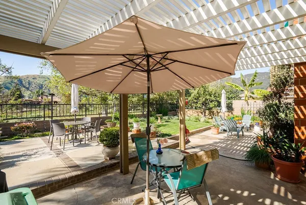 a view of a patio with a table and chairs under an umbrella