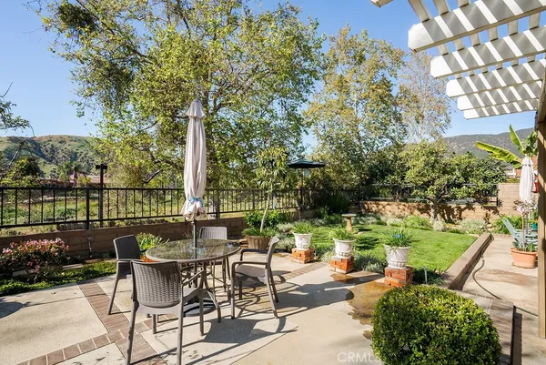 a view of a patio with couches table and chairs and potted plants