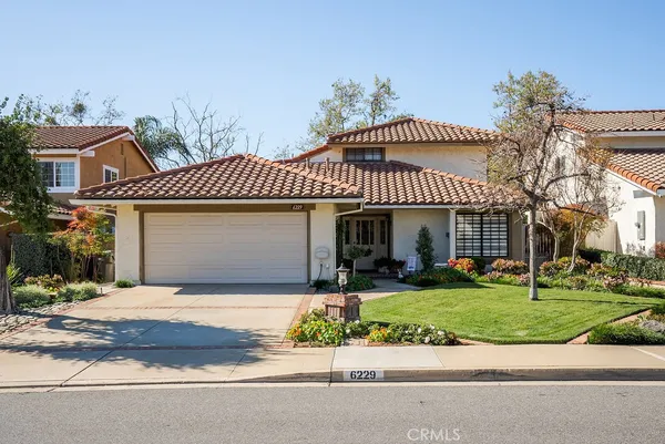 a front view of a house with a yard and potted plants