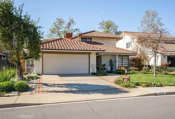 a front view of a house with a garden and plants