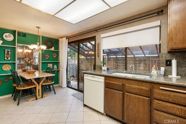 a dining room with stainless steel appliances granite countertop a refrigerator and a sink