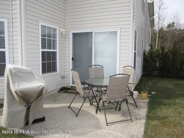 a patio with table and chairs and potted plants