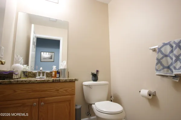 a bathroom with a granite countertop toilet sink and mirror