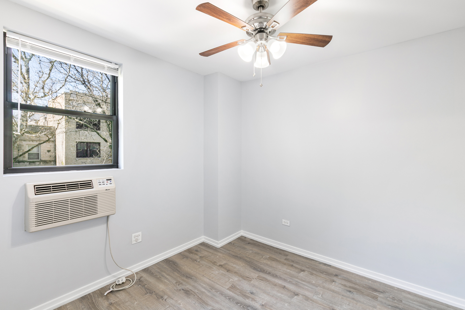4875 North Magnolia Avenue, Unit 201 Chicago, IL 60640 - Photo 5 of 12 an empty room with a window and a fan