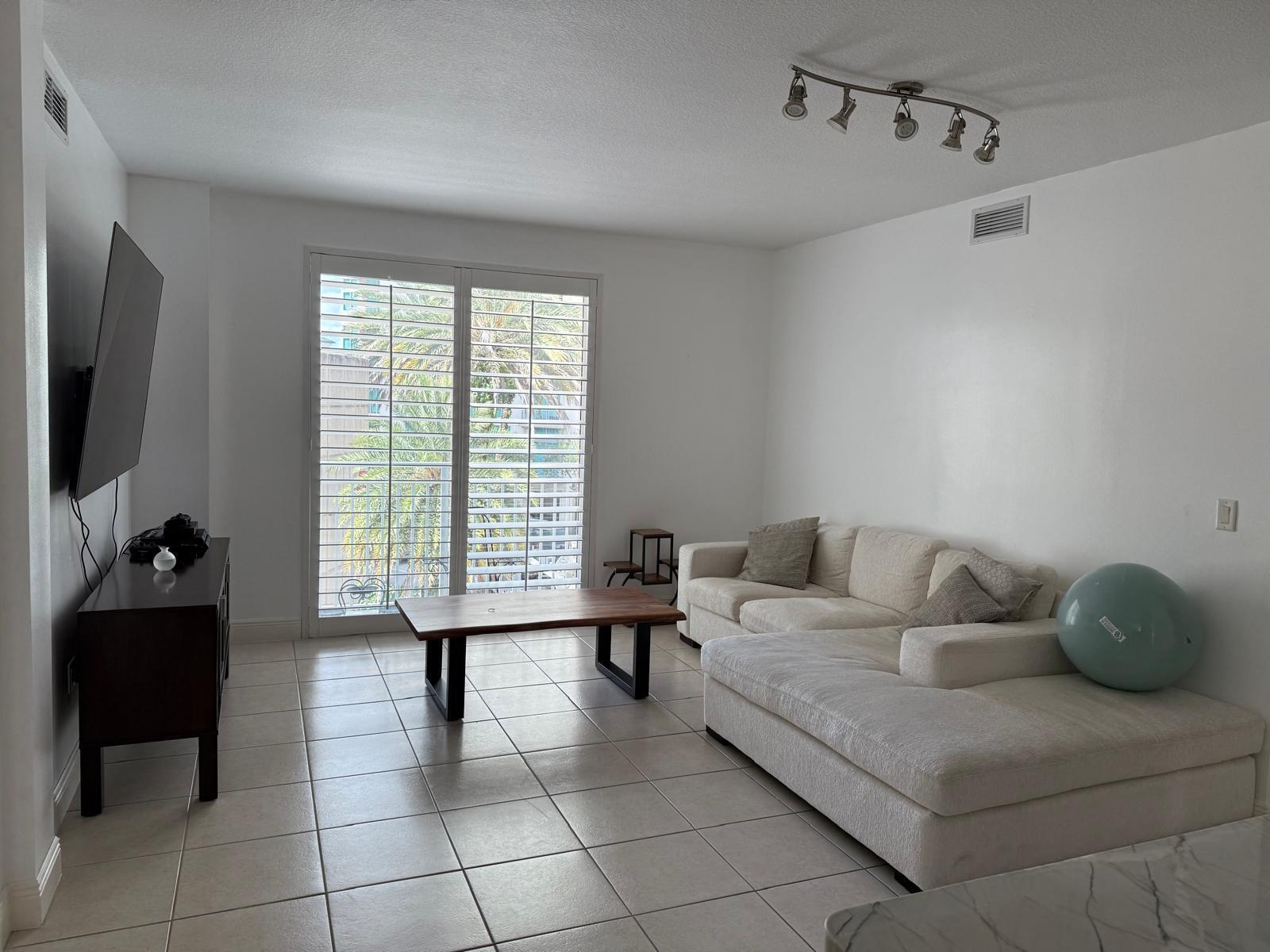 7275 Southwest 90th Way, Unit 311 Miami, FL 33156 - Photo 3 of 17 a living room with furniture and a flat screen tv