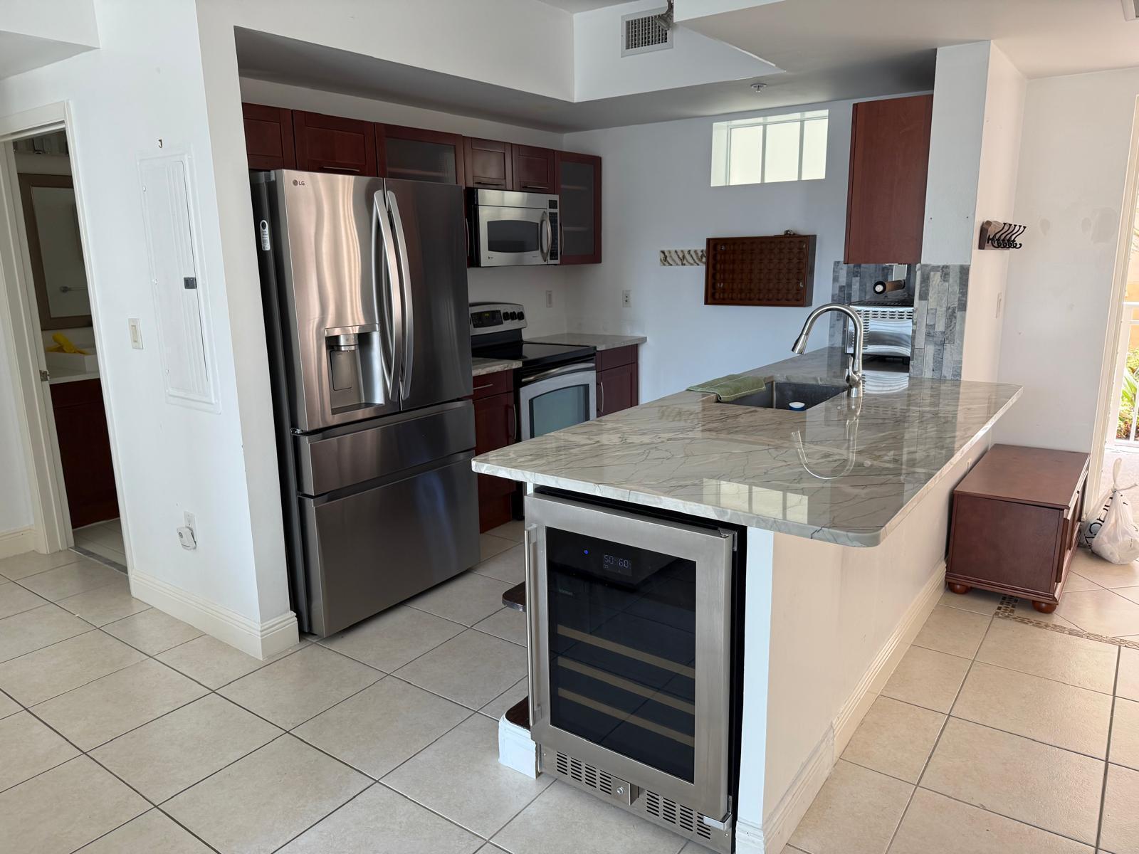 7275 Southwest 90th Way, Unit 311 Miami, FL 33156 - Photo 5 of 17 a kitchen with appliances cabinets and furniture